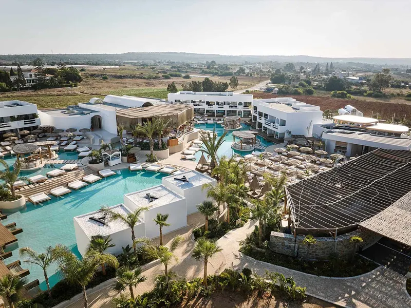 Resort buildings around the palm-lined pool club