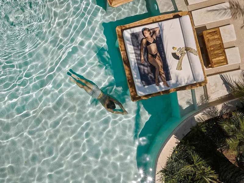 Floating day bed on turquoise pool water