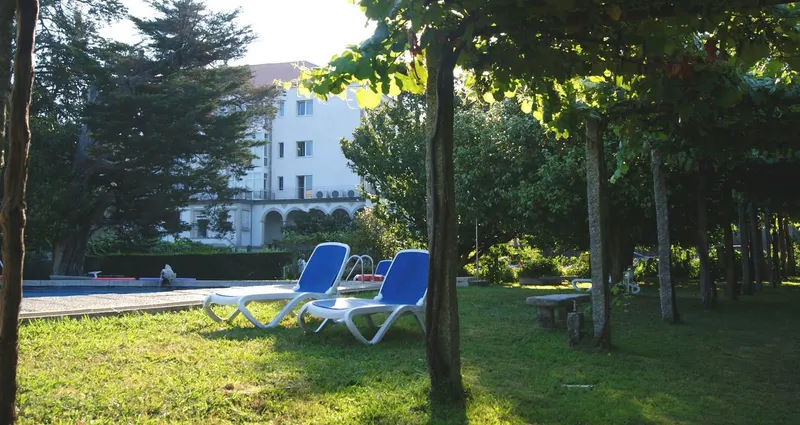 Pool loungers on the garden lawn under trees