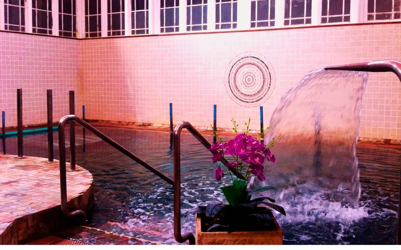 Pool with water jets and mosaic wall