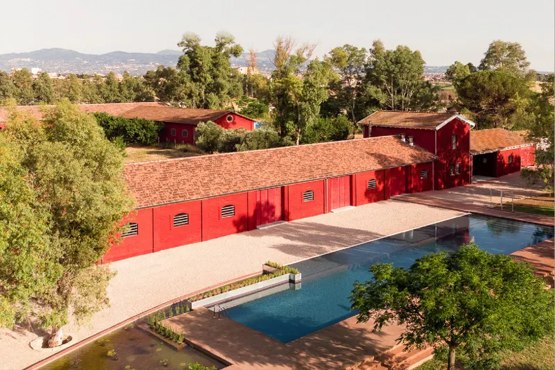 Aerial view of the red-roofed borgo, gardens and pool