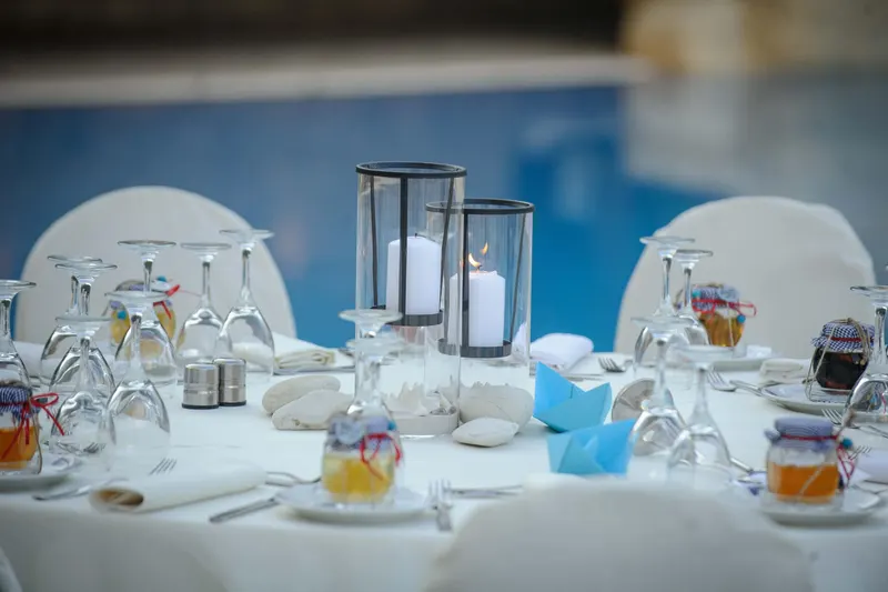 Table set with candles in front of the blue pool