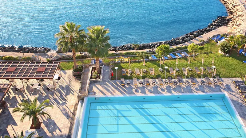 Aerial view of the outdoor pool, sunbeds and seafront gardens