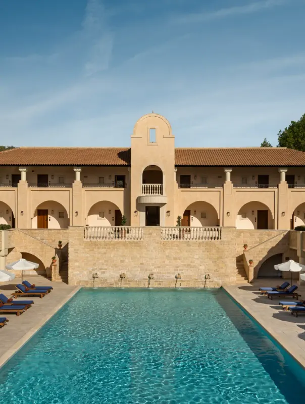 Rectangular outdoor pool below the hotel's arched facade