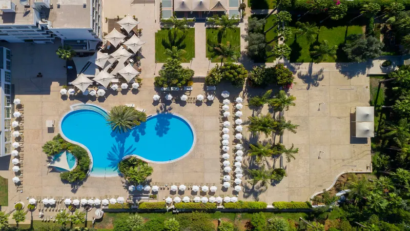 Aerial view of the curved pool with sunbeds and umbrellas