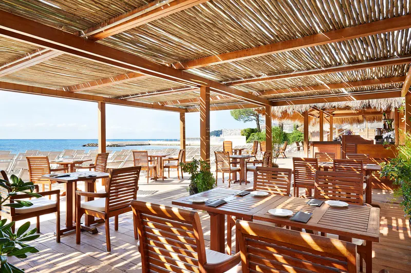 Alang beachfront restaurant terrace under a reed canopy facing the sea
