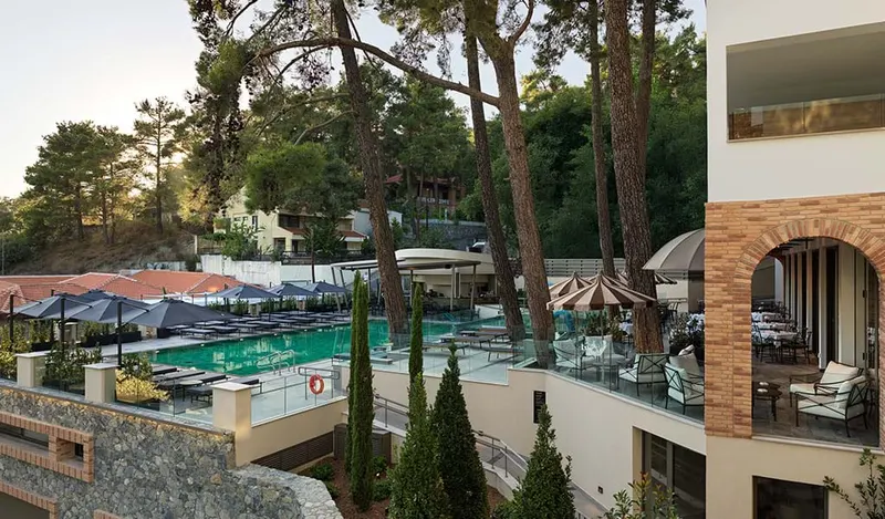 Pool terrace with parasols and forest behind
