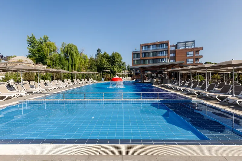 Outdoor thermal pool with umbrellas by day