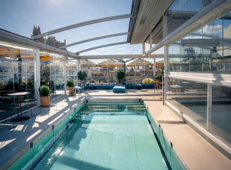 Rooftop pool under an open glass roof