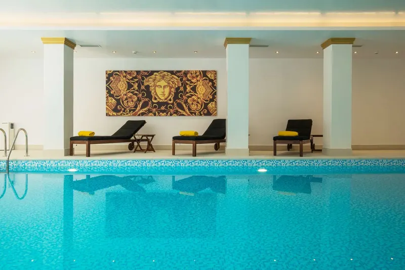 Indoor pool with black loungers
